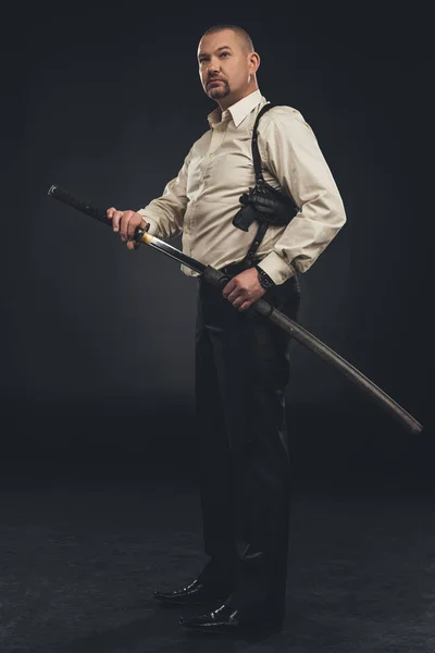 Vista lateral del miembro yakuza sacando su espada katana - foto de stock