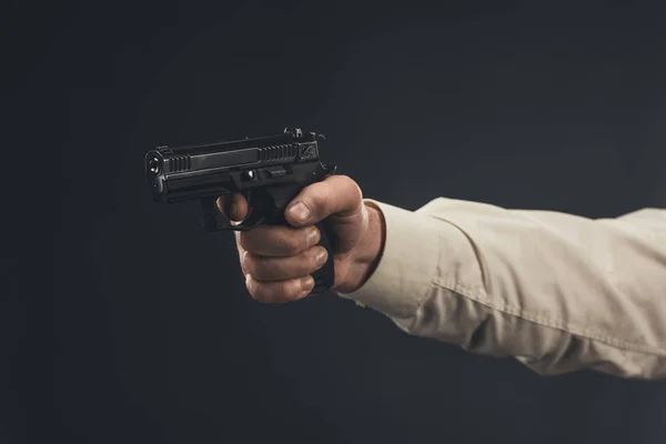 Cropped shot of man holding gun isolated on black — Stock Photo