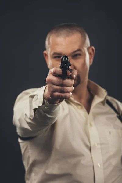Небезпечний чоловік прицільний пістолет на камеру ізольований на чорному — стокове фото