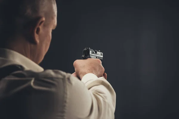 Крупным планом застрелен охранник, целящийся из пистолета — стоковое фото