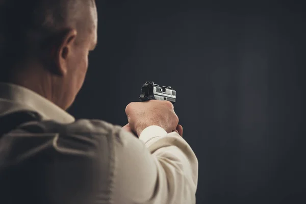 Primer plano del hombre de seguridad apuntando con un arma - foto de stock