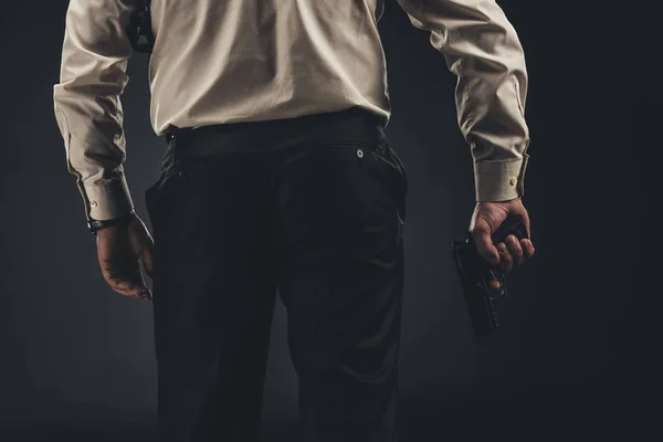 Cropped shot of man holding gun in hand — Stock Photo