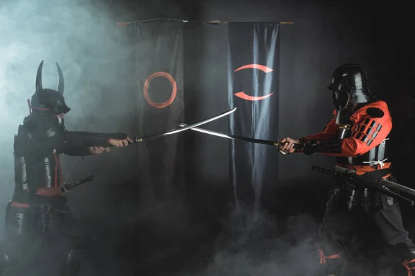 Guerreiros samurais cruzando espadas de katana na frente de símbolos de clã — Fotografia de Stock