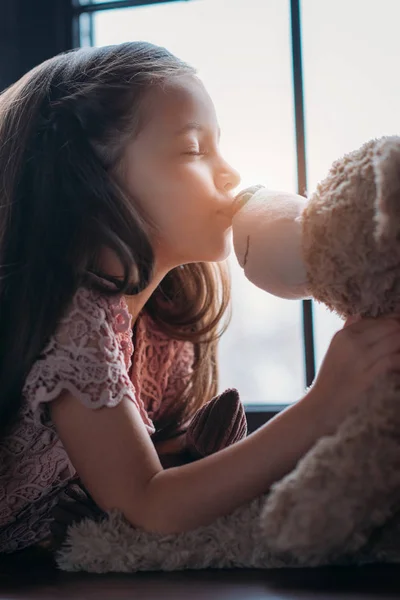 Schönes kleines Kind küsst Teddybär in die Nase — Stockfoto