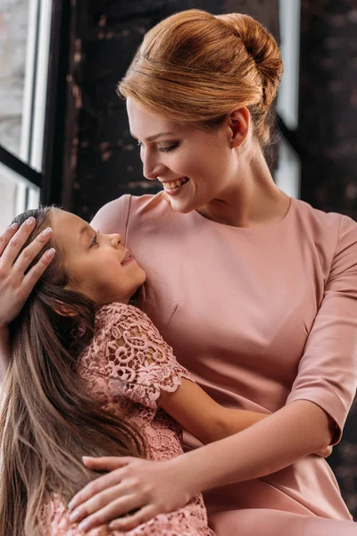 Junge schöne Mutter umarmt ihre kleine Tochter — Stockfoto