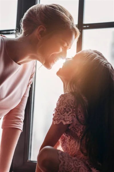 Madre e figlia coccole su sfondo sole — Foto stock