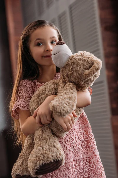 Entzückendes kleines Kind umarmt Teddybär zu Hause — Stockfoto