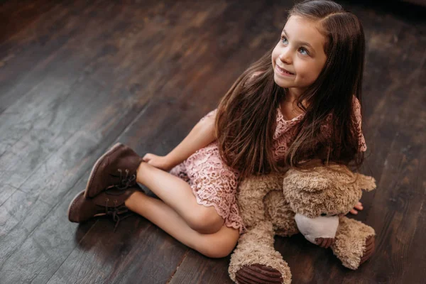 Adorable petit enfant assis sur le sol avec ours en peluche — Photo de stock