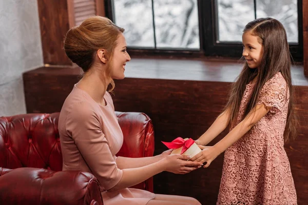 Figlia che dà regalo a felice giovane madre per la giornata delle madri — Foto stock