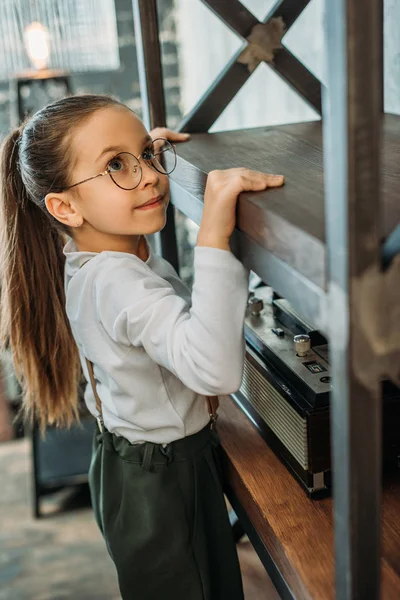 Чарівна маленька дитина скелелазіння на книжкових полицях в квартирах лофт — стокове фото