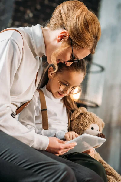 Feliz jovem mãe e filha usando tablet juntos em casa — Fotografia de Stock