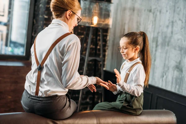 Stylische junge Mutter und Tochter spielen Pattycake — Stockfoto