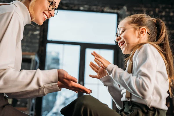 Happy young mother and daughter playing pattycake — Stock Photo