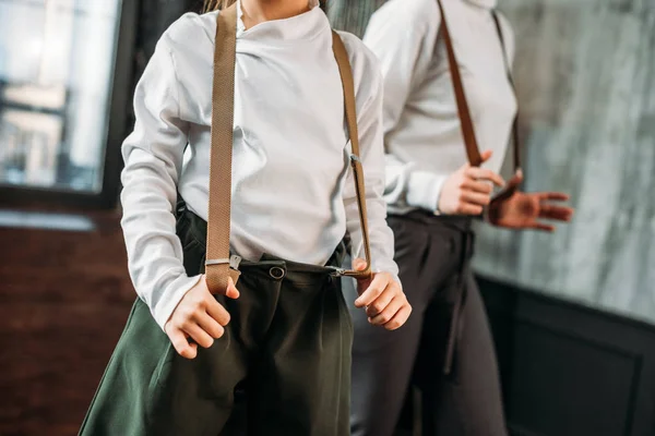 Cropped shot of mother and daughter in stylish clothing with suspenders — Stock Photo