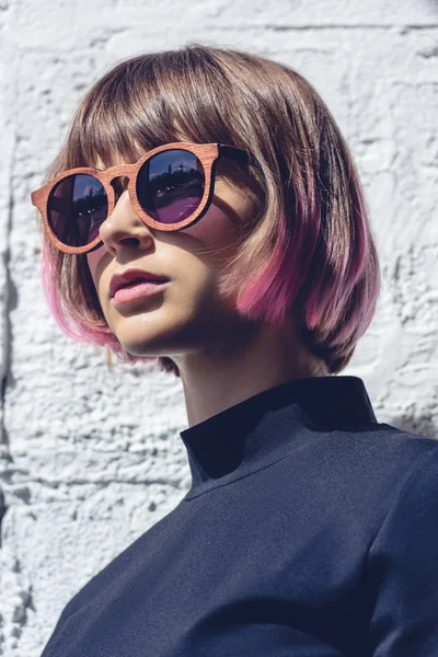 Портрет стильної дівчини з рожевим волоссям і сонцезахисними окулярами, що дивиться далеко — стокове фото