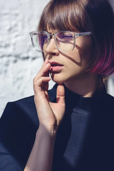 Bella donna elegante con capelli rosa e occhiali toccare le labbra con mano — Foto stock