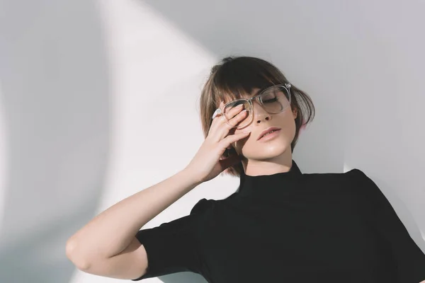 Fashionable girl touching eye with hand on white — Stock Photo