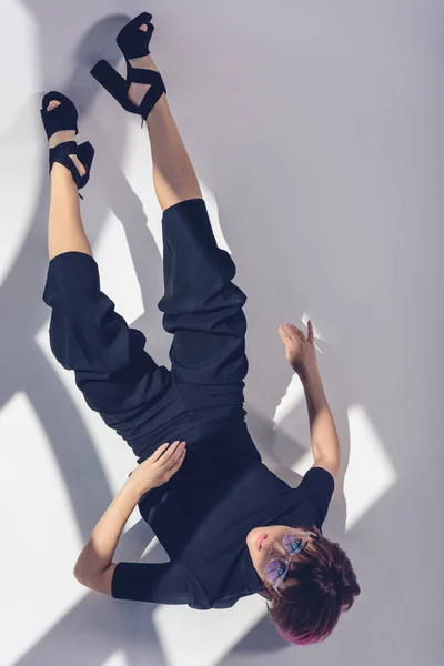 Vista superior da menina elegante deitado em roupas pretas no branco — Fotografia de Stock