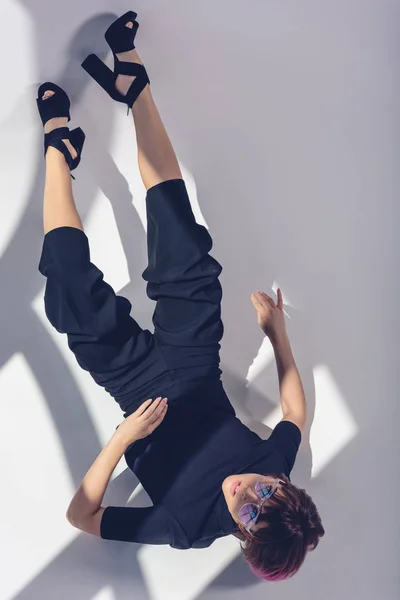 Top view of stylish girl lying in black clothes on white — Stock Photo