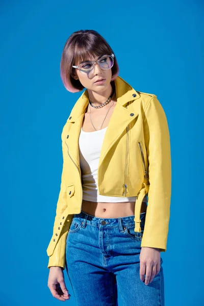 Stilvolles Mädchen mit Brille schaut vereinzelt auf blauem Grund weg — Stockfoto