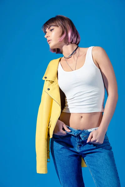 Girl in trendy clothes with unbuttoned jeans looking away isolated on blue — Stock Photo