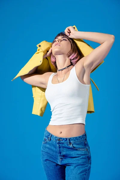 Chica deportiva de moda mirando hacia arriba con las manos arriba aislado en azul - foto de stock