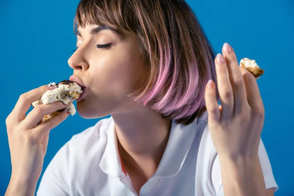 Sexy atractiva mujer comer pedazo de pastel aislado en azul - foto de stock