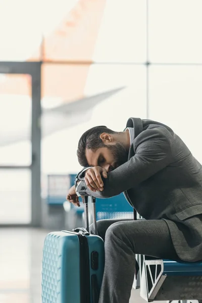 Exhausted businessman sleeping at airport lobby while waiting for flight — Stock Photo