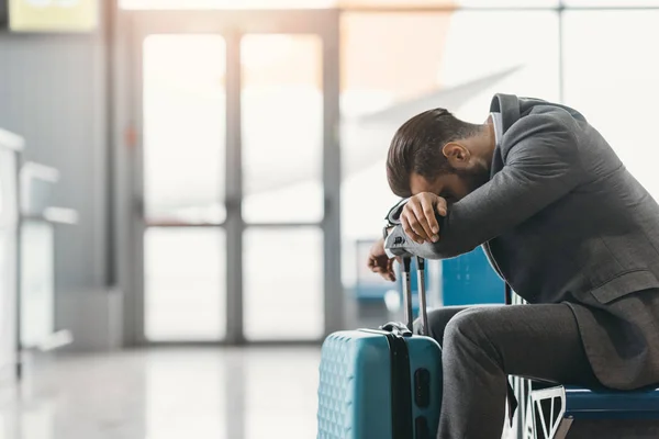 Homem de negócios cansado dormindo no lobby do aeroporto enquanto espera pelo voo — Fotografia de Stock