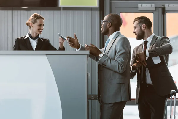 Бизнесмен, стоящий у стойки регистрации в аэропорту, поторопитесь с концепцией самолета — стоковое фото
