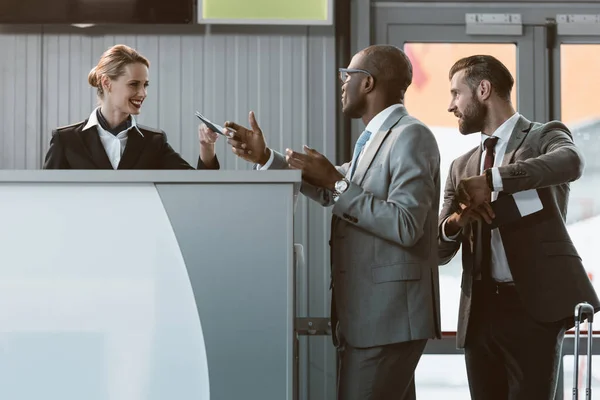 Hombre de negocios de pie en el mostrador de facturación del aeropuerto, date prisa en concepto de avión - foto de stock