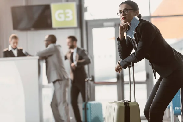 Вдумчивый молодой бизнесмен ждет полета в вестибюле аэропорта — стоковое фото