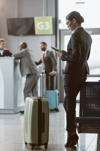 Atractivo hombre de negocios esperando el vuelo en el vestíbulo del aeropuerto - foto de stock