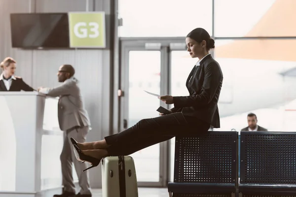 Homme d'affaires regardant le billet en attendant le vol dans le hall de l'aéroport — Photo de stock