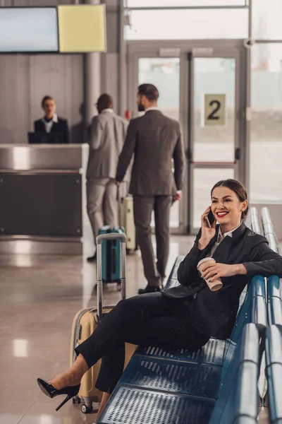 Jeune femme d'affaires attendant l'avion dans le hall de l'aéroport et parlant par téléphone — Photo de stock