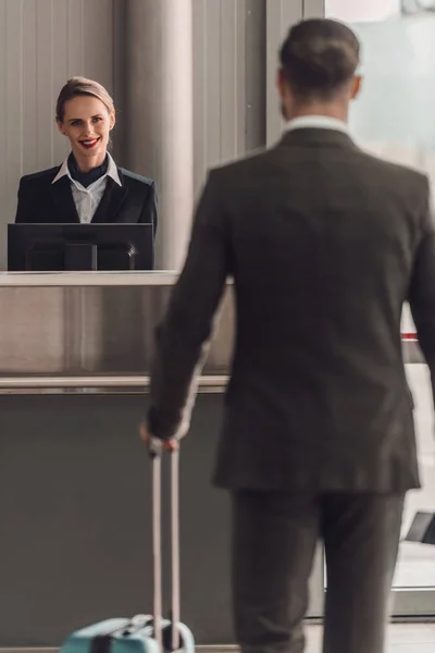 Задний вид бизнесмена, идущего в аэропорт проверить в прилавок — стоковое фото