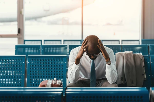 Втомлений бізнесмен чекає на рейс у фойє аеропорту — стокове фото