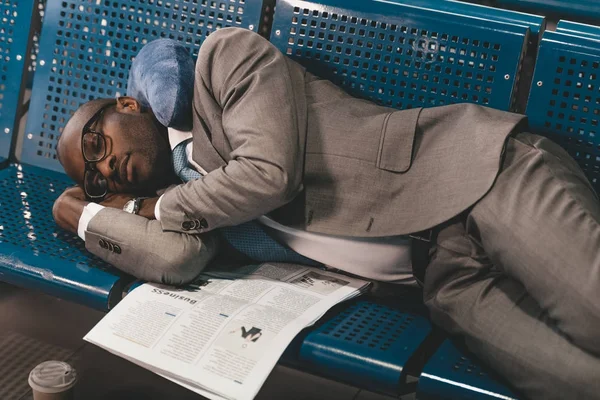 Homme d'affaires fatigué dormant sur des sièges en attendant le vol dans le hall de l'aéroport — Photo de stock
