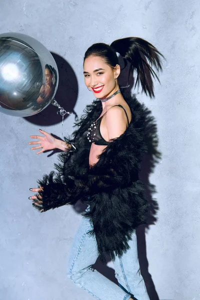 Beautiful fashionable asian girl with silver balloon smiling at camera — Stock Photo