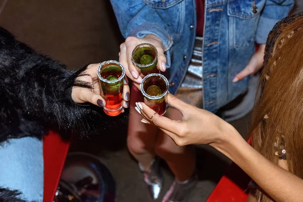 Tiro recortado de mujeres elegantes sosteniendo vasos con cócteles - foto de stock