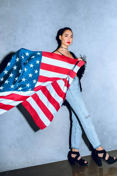 Belle femme asiatique avec drapeau américain contre mur en béton — Photo de stock