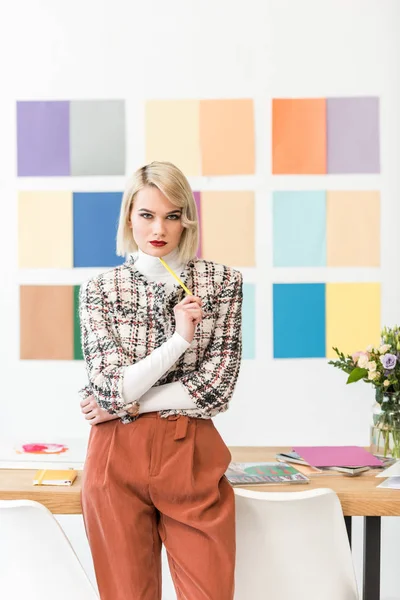 Attractive fashion magazine editor with colors palette on wall in modern office — Stock Photo