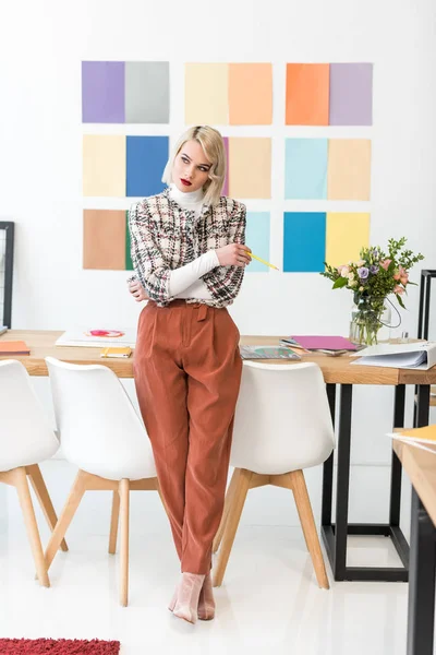 Editor de revista de moda bonita com paleta de cores na parede no escritório — Fotografia de Stock