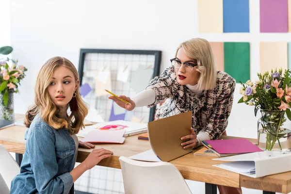 Modische Zeitschriftenredakteure erledigen Papierkram in modernen Büros mit Farbpalette — Stockfoto