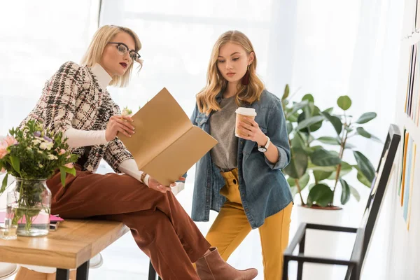 Modische Zeitschriftenredakteure, die mit Dokumenten arbeiten und Kaffee trinken — Stockfoto