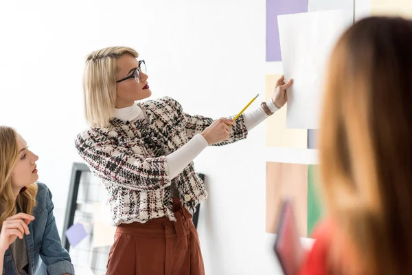 Modische Zeitschriftenredakteure, die in modernen Büros mit Dokumenten arbeiten — Stockfoto