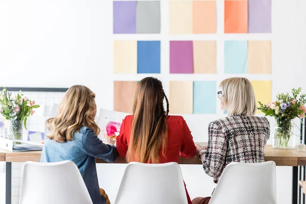 Back view of magazine editors working with color palette an wall — Stock Photo