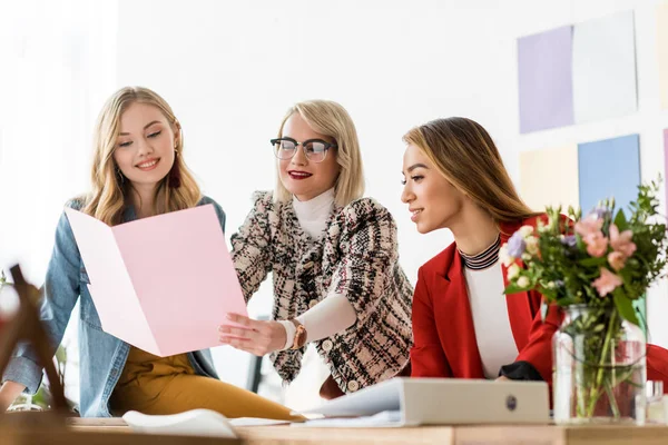 Éditeurs de magazines à la mode travaillant avec des documents dans un bureau moderne — Photo de stock