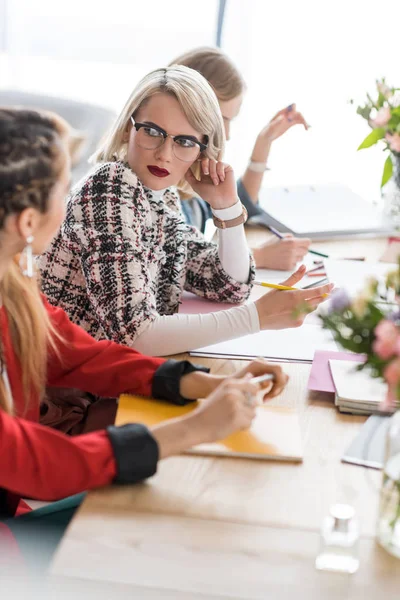 Redattori di rivista eleganti che lavorano con documenti in ufficio moderno — Foto stock