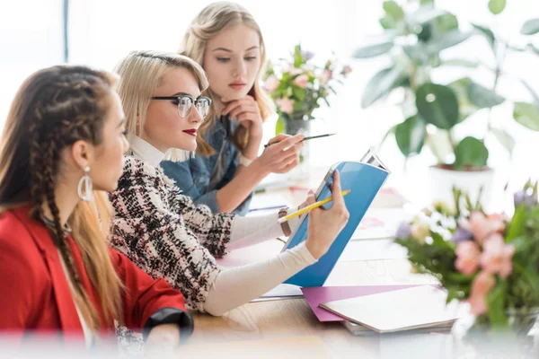 Schöne Zeitschriftenredakteure, die in modernen Büros mit Dokumenten arbeiten — Stockfoto